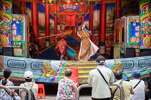 寺庙前很多人在看台湾传统民间戏曲歌仔戏演出
