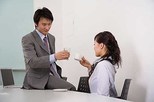 会议室内一起喝咖啡的男女职员