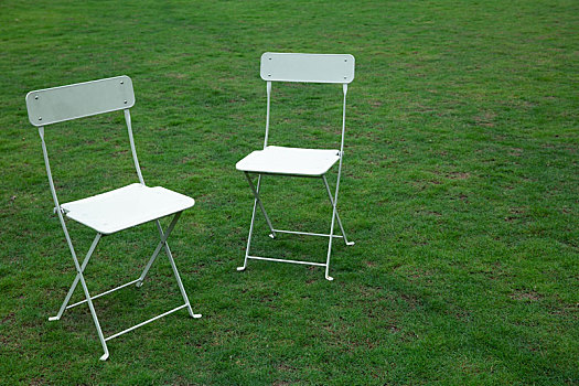草地上的两把白色椅子