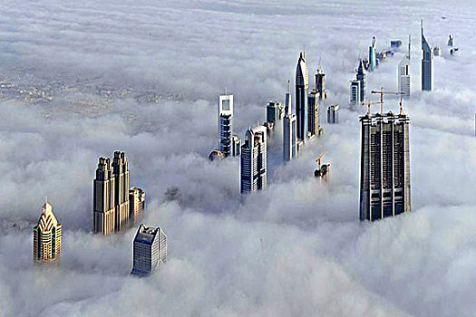登迪拜哈里发塔雾云中看迪拜城