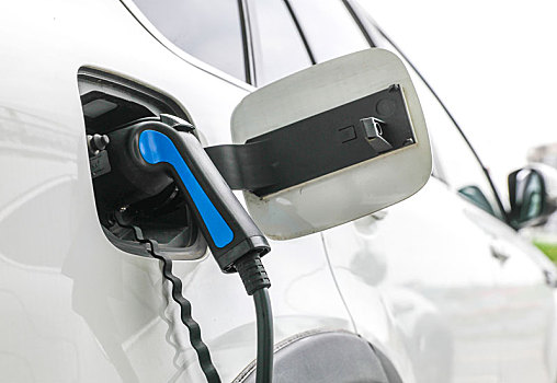 新能源汽车充电站正在充电的汽车和充电枪特写
