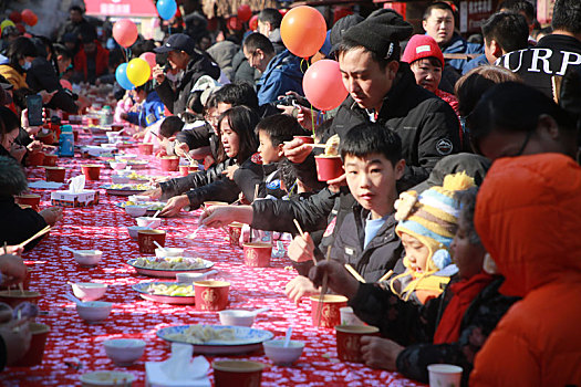 小镇摆下百米长桌宴,市民游客新年吃饺子交好运