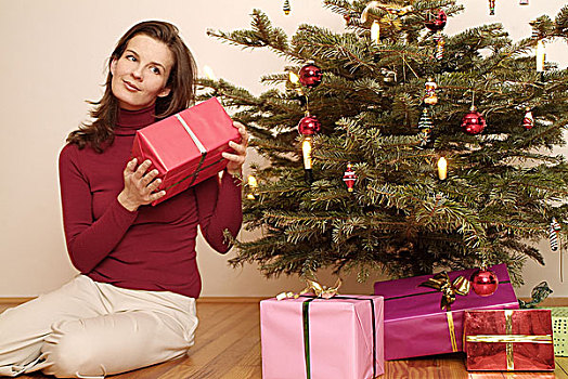 圣诞树,女人,年轻,坐,圣诞礼物,包装,序列,圣诞节,聚会,圣诞时节,准备,礼物,20-30岁,黑发,长发,喜悦,期待,好奇,听