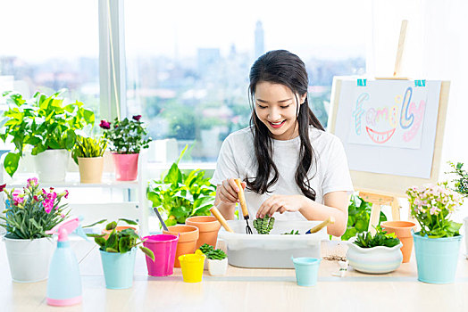 年轻女子在家种植盆栽