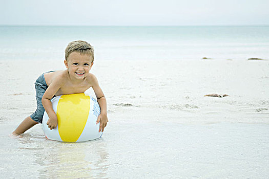 小男孩,躺着,上面,水皮球,海滩,看镜头,微笑