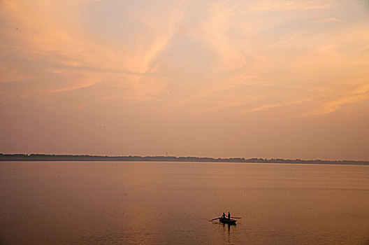 夕阳下湖面上捕鱼的小船
