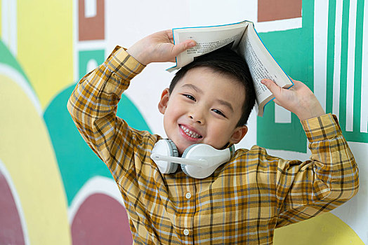 小男孩頭頂書本
