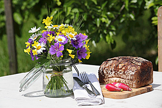 花,罐头瓶,长条面包,桌上