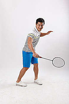 一个穿休闲装打羽毛球的青年男士