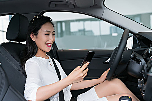 年轻女子在车里使用手机