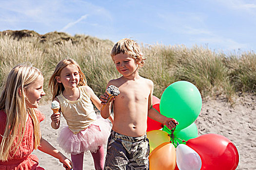 三个孩子,吃,冰淇淋,海滩,气球,威尔士,英国