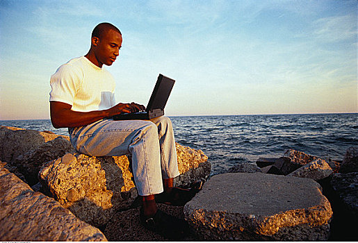 男人,坐,岩石上,使用笔记本,电脑,靠近,水