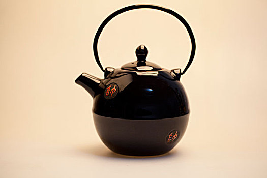 白色背景下平视具有中国传统特色的黑釉陶瓷茶壶