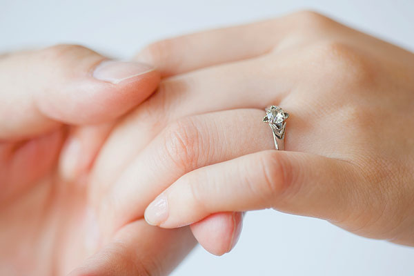 戴着结婚戒指牵手的情侣