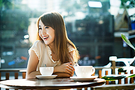 年轻女性在露天咖啡厅喝咖啡