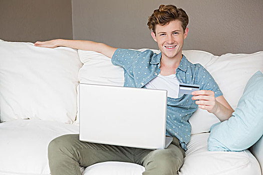 高兴,男青年,坐,沙发,网上购物,笔记本电脑,在家,客厅