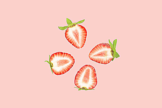 切开的草莓排列在粉红色的背景上