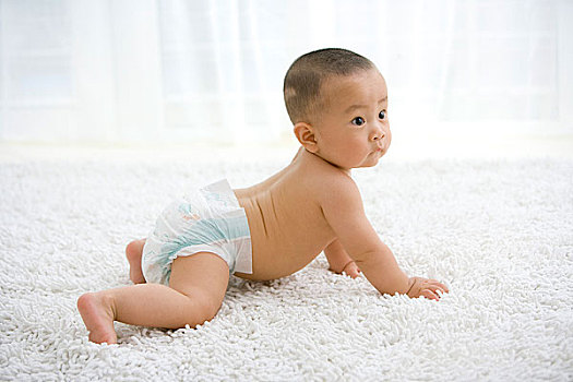 一個在地毯上玩耍的嬰兒