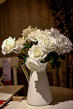 白色花瓶中插着白色的玫瑰花