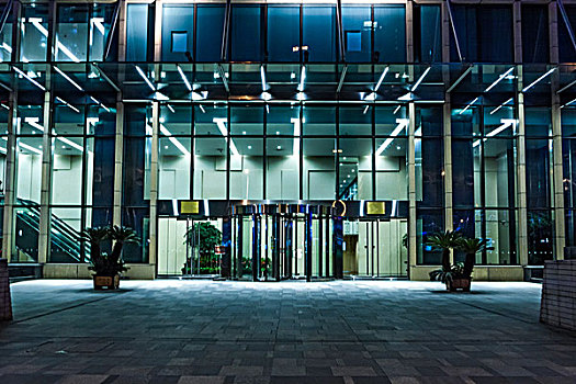 玻璃大门在中国上海,在晚上的现代化办公大楼