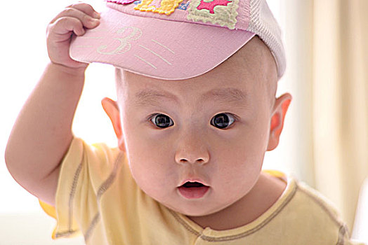 8个月的婴儿手抓帽子注视镜头