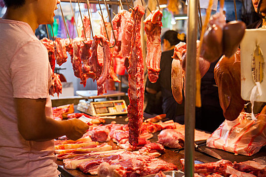 猪肉摊贩架子上摆满着不同部位的猪肉