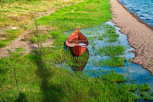 草地上搁浅的红色小船