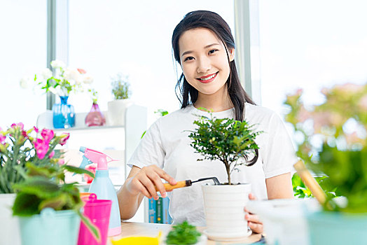 年轻女子在家种植盆栽