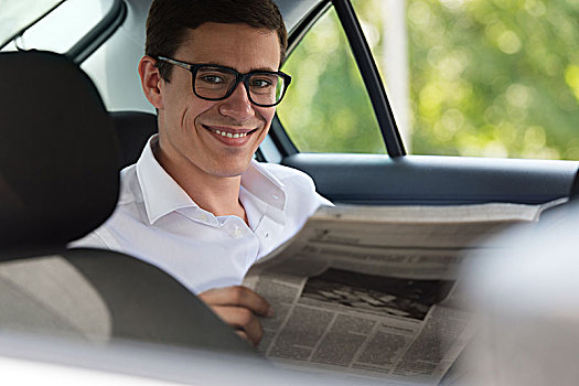 高兴,男青年,读报,汽车,微笑