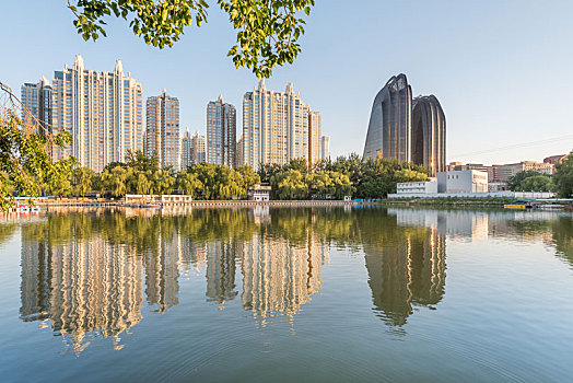 黄昏中国北京朝阳公园湖边的树林建筑