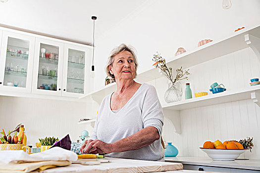老年,女人,看,上方,肩部,准备,蔬菜,厨房用桌