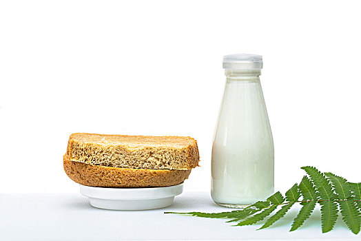 餐桌上的面包和牛奶,简单的早餐,一枝绿叶点缀