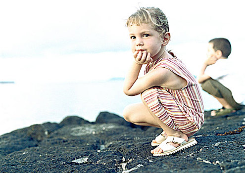 两个孩子,蹲,岩石上