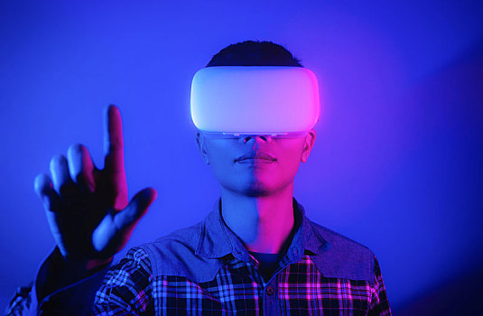 戴着vr虚拟现实头盔体验元宇宙未来技术点击屏幕