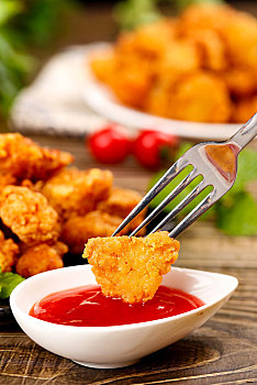 叉子上插着沾番茄汁的鸡米花