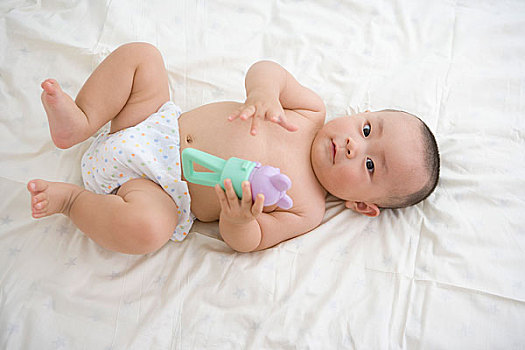 躺在床上玩耍的嬰兒