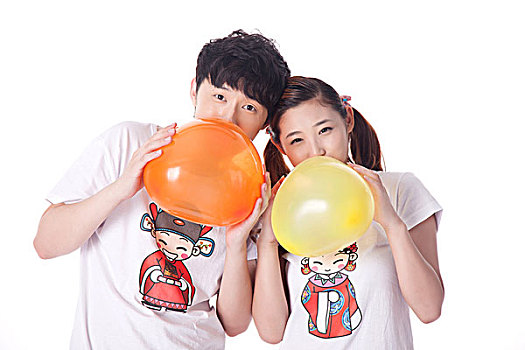 年轻情侣一起吹气球