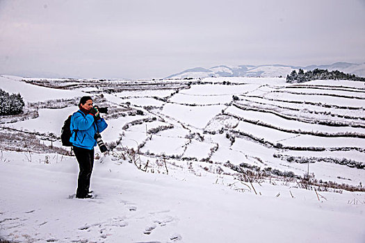 云南东川红土地雪原中的摄影爱好者