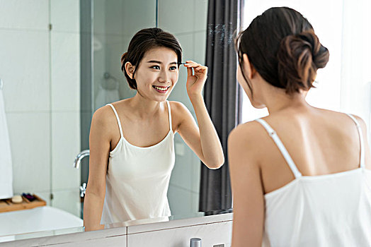 年轻女子照镜子整理妆容