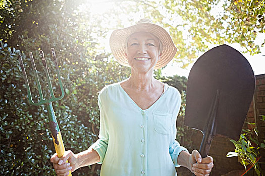 逆光,头像,微笑,老年,女人,拿着,园艺叉,铲,后院