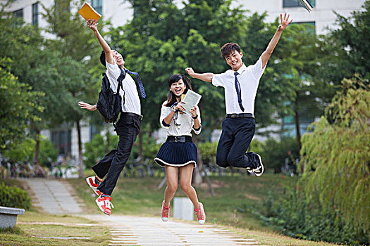 三个大学生在校园跳跃