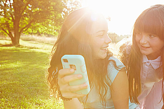 两个女孩,看,智能手机,日光,公园
