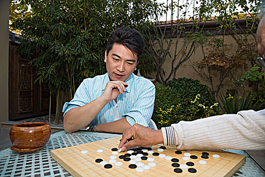 父子在庭院里下棋