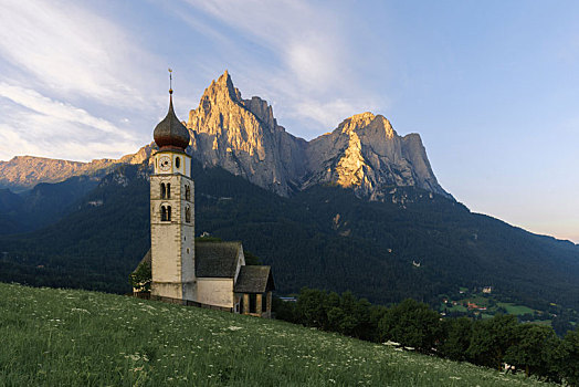 意大利多洛米蒂山间的教堂与远方清晨的高原山峰