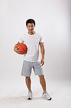 一个穿休闲装打篮球的青年男士