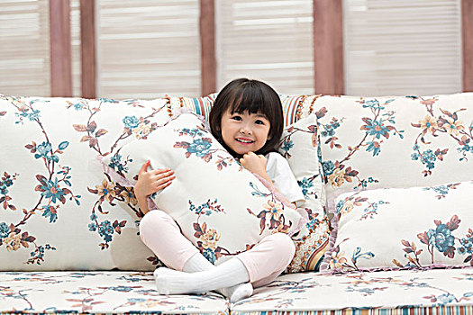 快乐的小女孩坐在沙发上