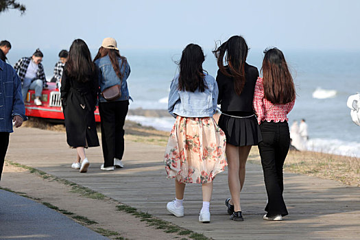 山东省日照市,面朝大海春暖花开,游客奔向海边休闲散步感受美好春天