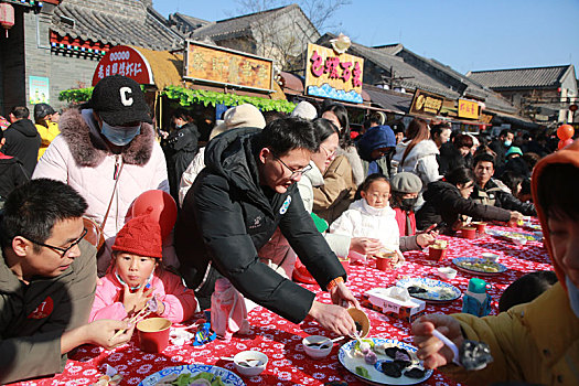 小镇摆下百米长桌宴,市民游客新年吃饺子交好运