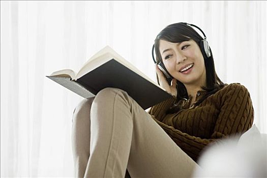 女青年,听,头戴式耳机,读,书本