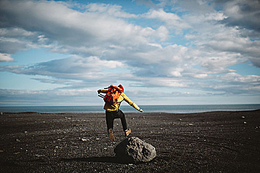 后视图,中年,男人,跳跃,上方,漂石,火山地貌,冰岛